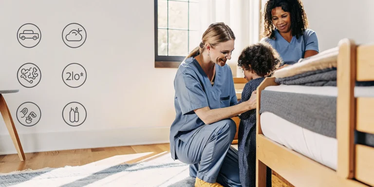 A pediatric registered nurse caring for a child in a calm home bedroom with a parent nearby in Warner Robins, Georgia